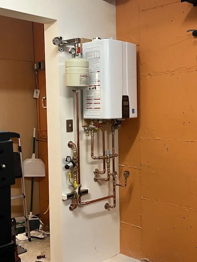 Plumbing technician inspecting water heater connections in Krum